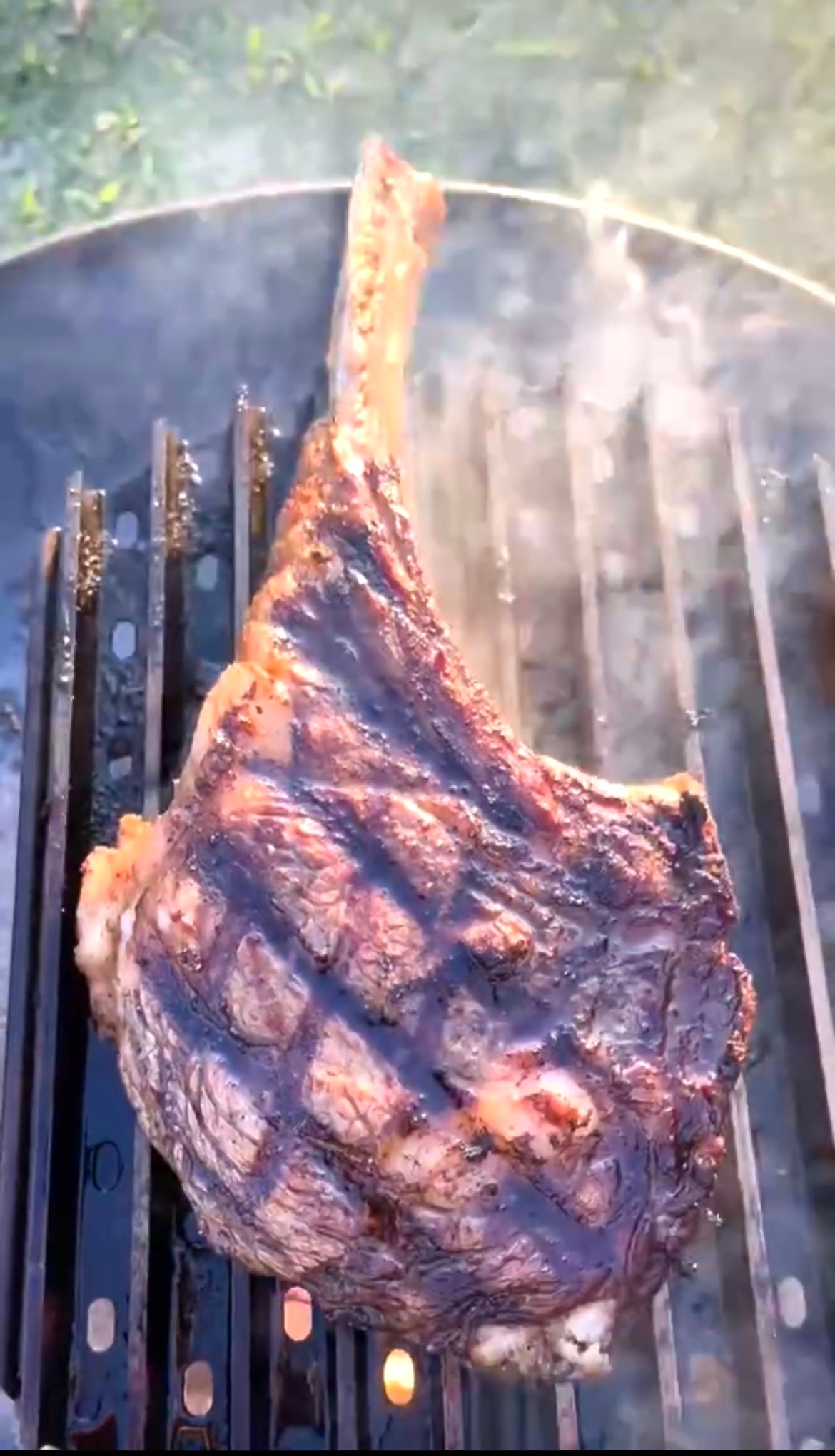 Grilled steak on a barbecue grill with smoke