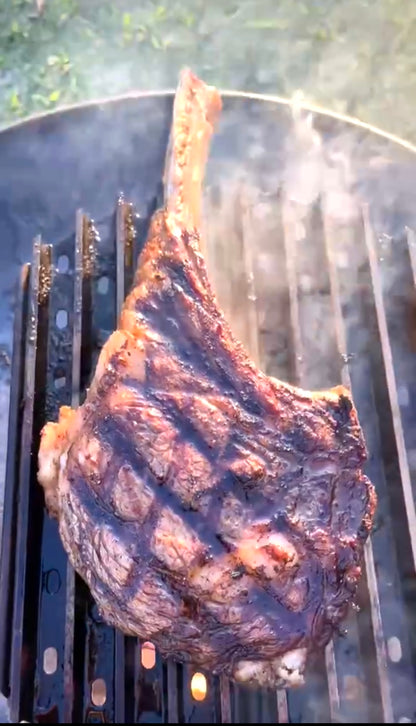 Grilled steak on a barbecue grill with smoke