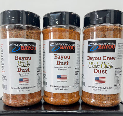 Three bottles of Smokehouse Bayou seasonings including Bayou Steak Dust, Bayou Dust, and Bayou Crew Chick Chick Dust